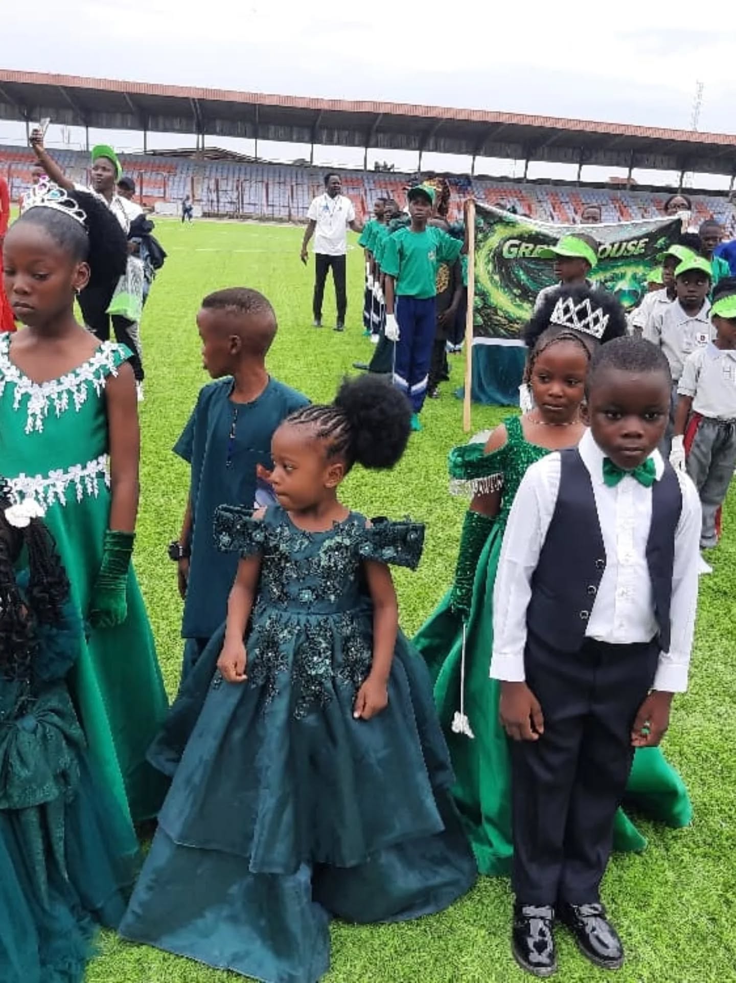 Pupils in green costumes marching with the Green House banner